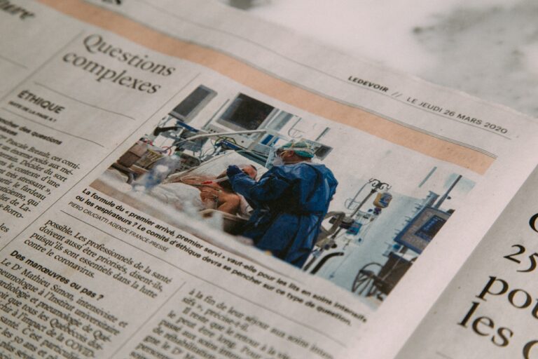 A newspaper article with an image of a doctor in blue scrubs treating a patient in a bed